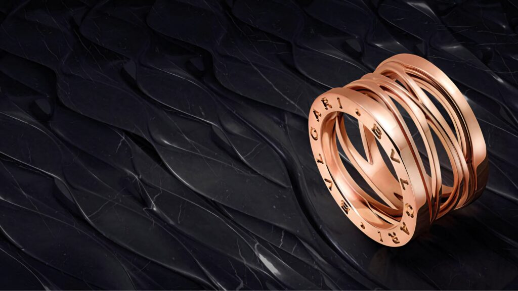 Luxurious rose gold Bvlgari ring with intertwined design on dark textured background wallpaper