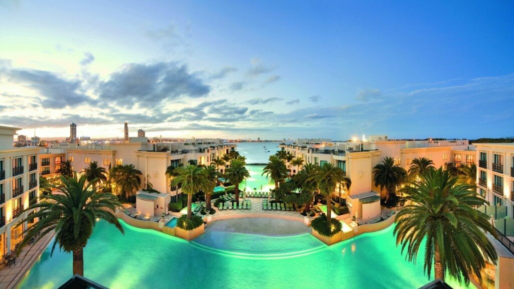 Luxury Seaside Resort Wallpaper: Palm Trees & Clear Blue Sky