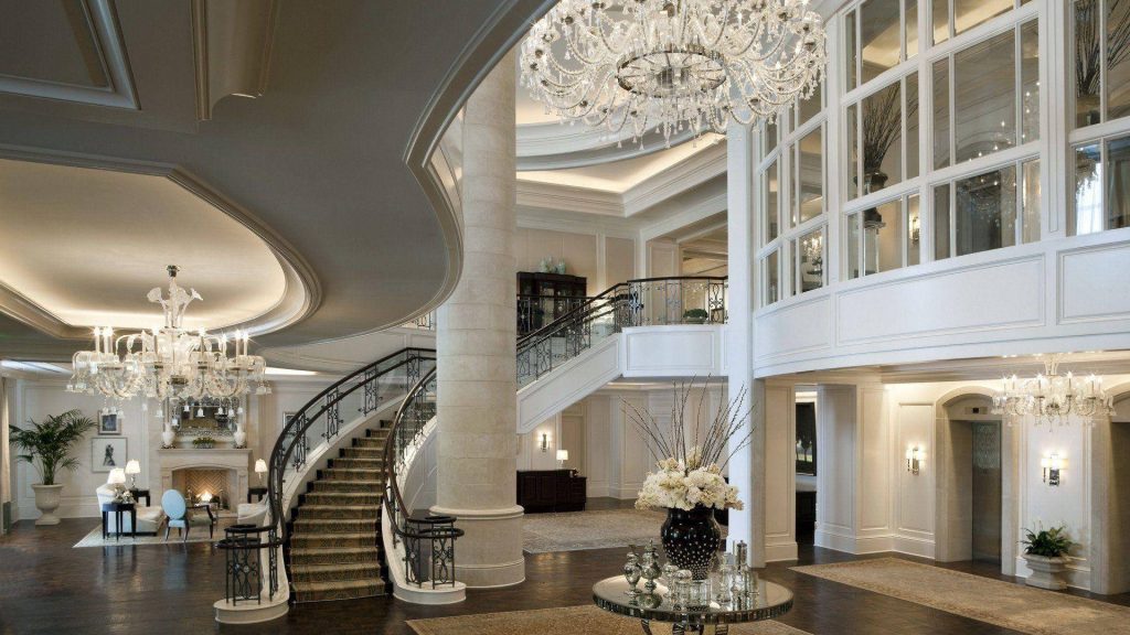 Luxurious St Regis Atlanta lobby with grand staircase crystal chandeliers and elegant white interior Wallpaper