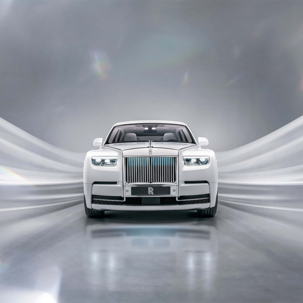 Luxurious white Rolls Royce Phantom in modern sleek setting with elegant flowing background wallpaper