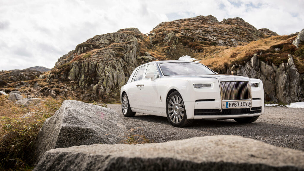 White Rolls-Royce Phantom parked by rugged rock formations luxury car nature landscape wallpaper