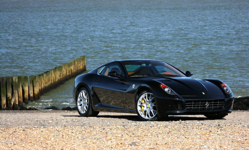 Elegant Black Ferrari on Beach: Luxury Car Wallpaper