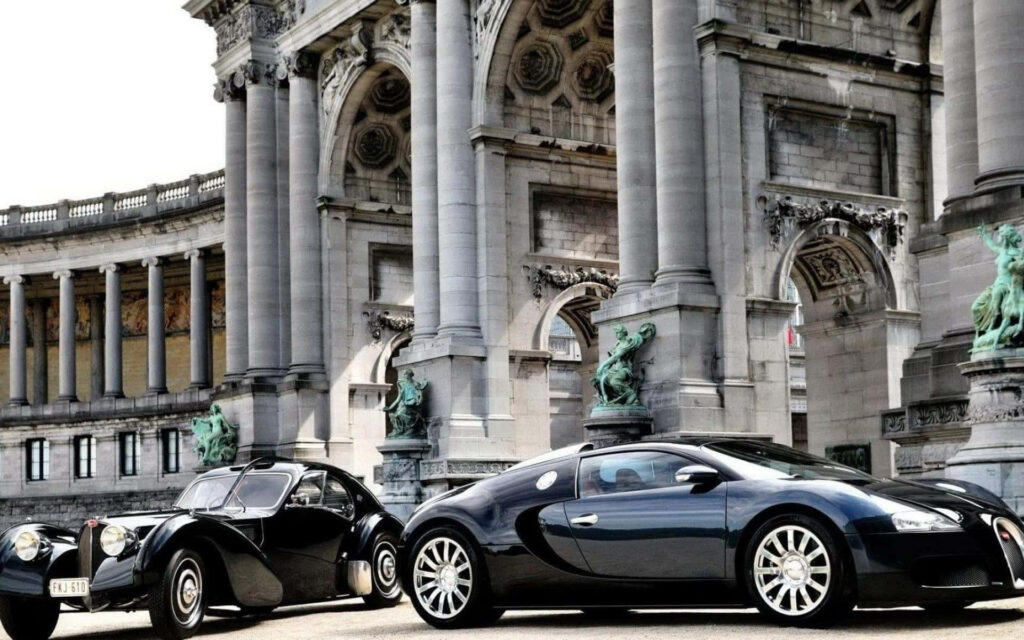 Two luxury Bugatti cars including black Veyron in front of historic building with grand columns Wallpaper