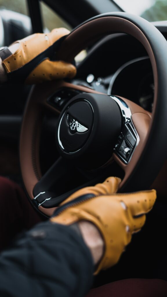 Luxurious Bentley Interior Wallpaper with Gloved Hands on Steering Wheel