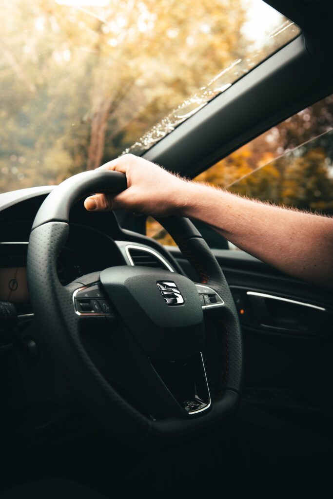Luxury Car Interior: Close-Up of Hand on Steering Wheel Wallpaper