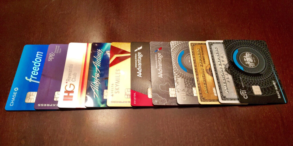 Colorful premium credit cards with metallic finishes displayed on polished wooden table background Wallpaper