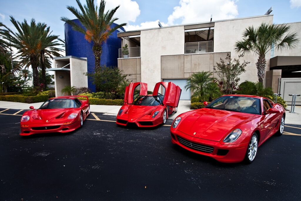 Three Red Ferraris Amid Palm Trees: Exotic Luxury Wallpaper