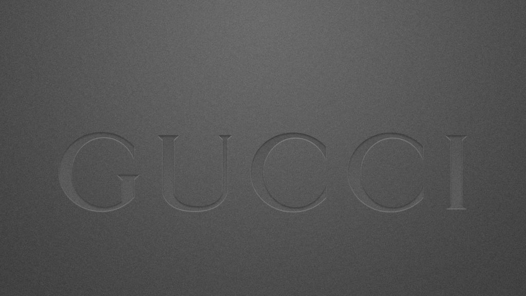 Luxury 4k Gucci logo wallpaper embossed on dark gray textured minimalist background