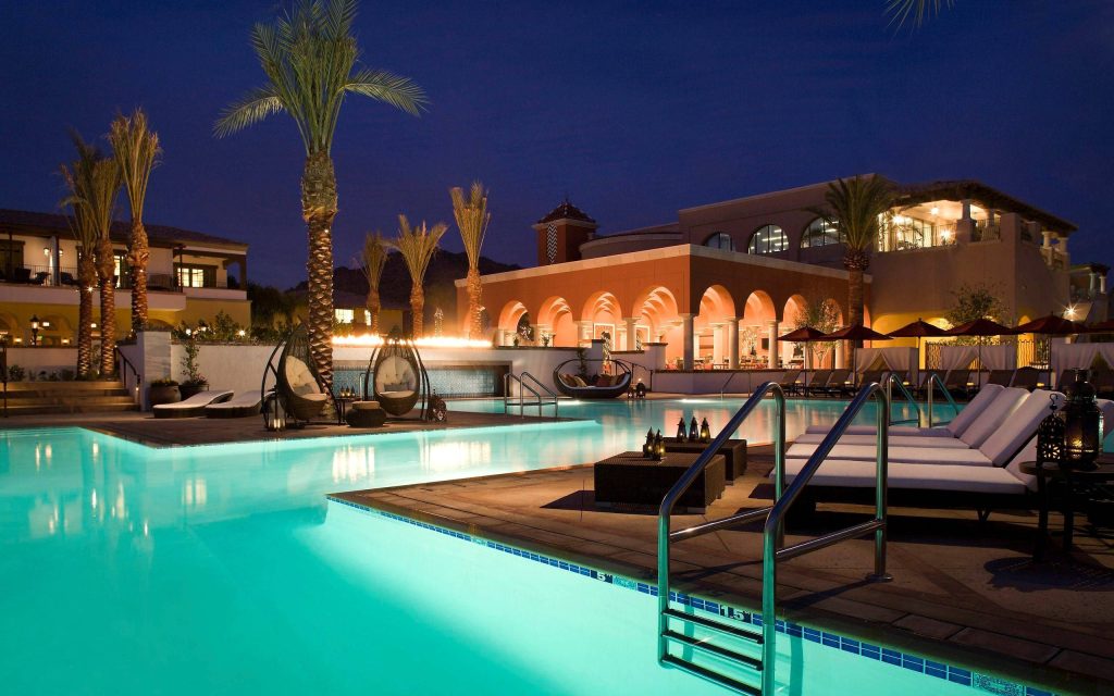 Luxurious mansion pool at dusk Mediterranean style architecture palm trees and lounge chairs wallpaper