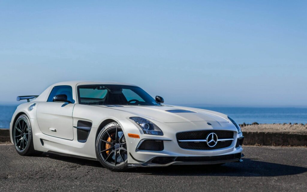 Elegant White Mercedes-Benz SLS AMG by Serene Coastal Background Wallpaper