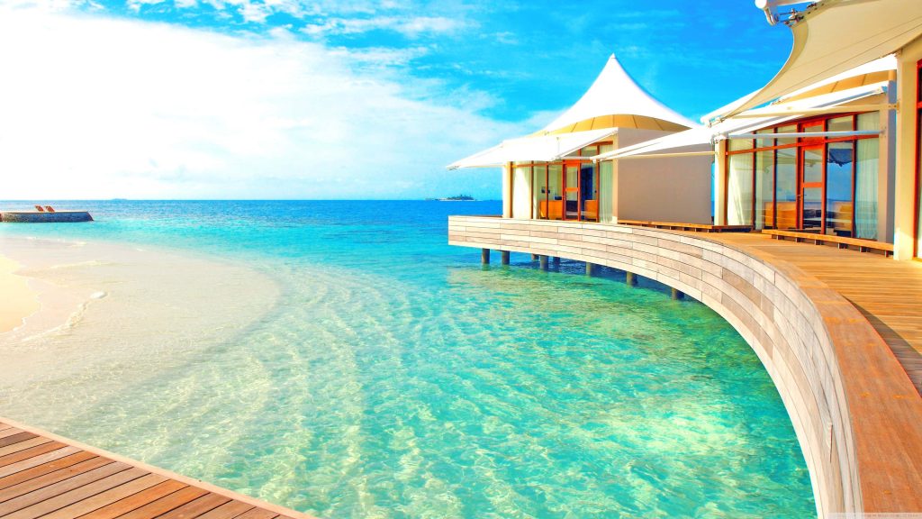 Overwater Maldives villa wallpaper with white canopy bungalows turquoise ocean blue sky