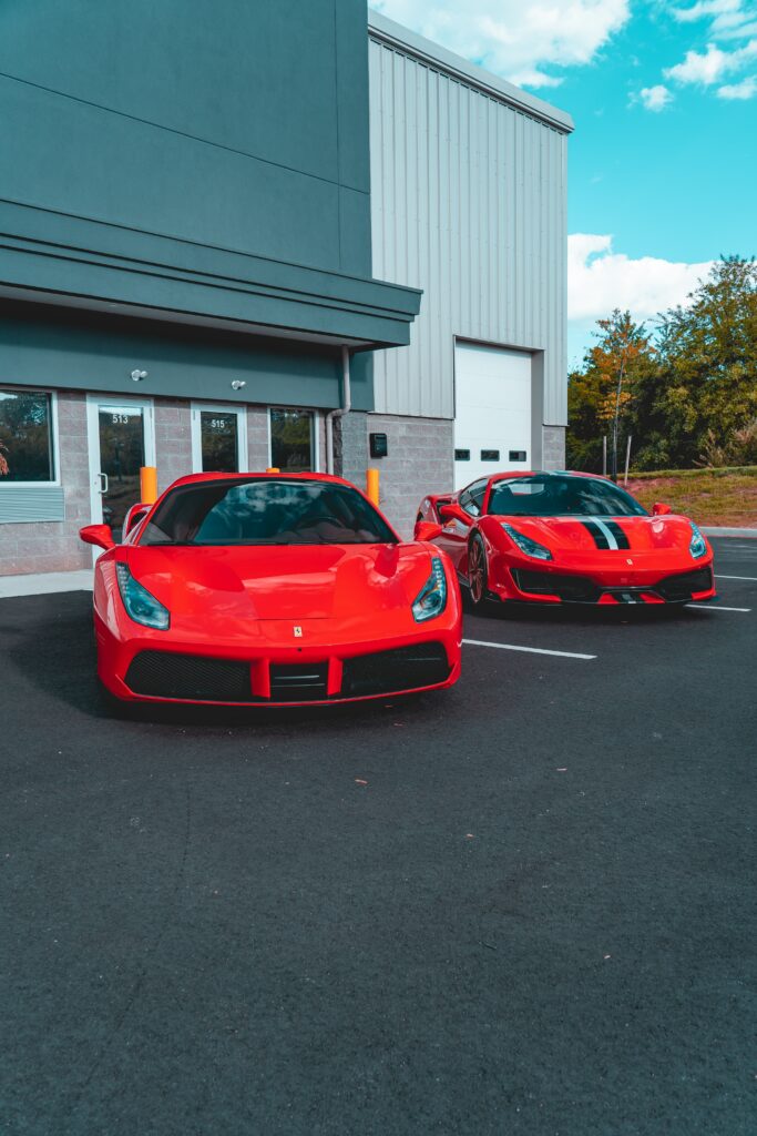 Red Ferrari Sports Cars in Front of Modern Building – Luxury Wallpaper