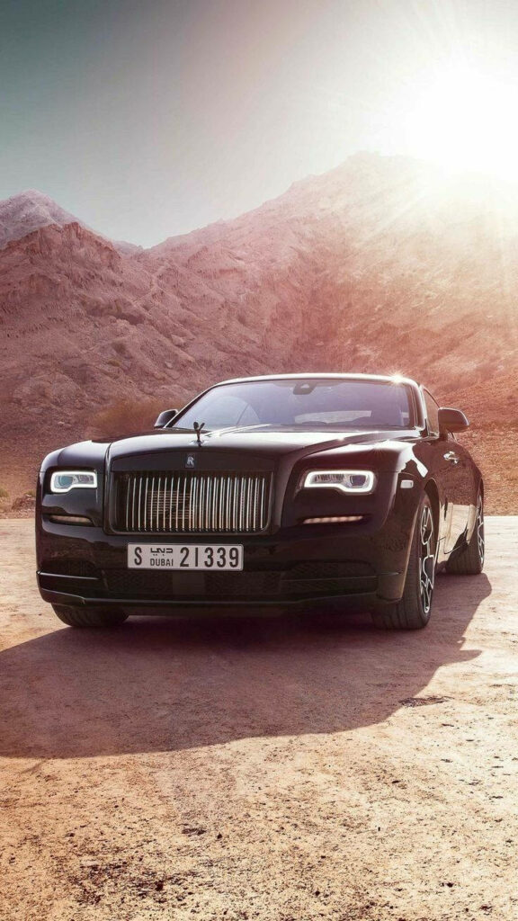 Rolls-Royce Wraith luxury car on sunlit desert with rugged mountains clear sky 4K wallpaper