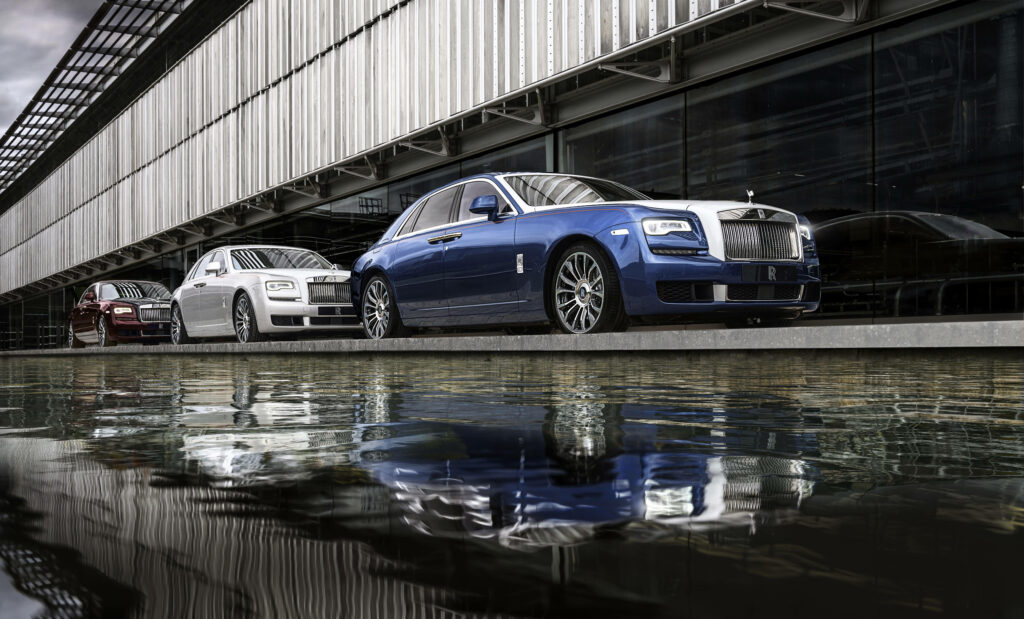 Luxury Rolls Royce cars parked by modern glass building with reflections in calm water 4K wallpaper