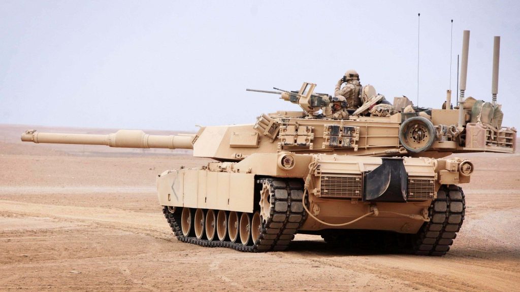 M1 Abrams tank crossing rugged desert terrain detailed military wallpaper background HD photo