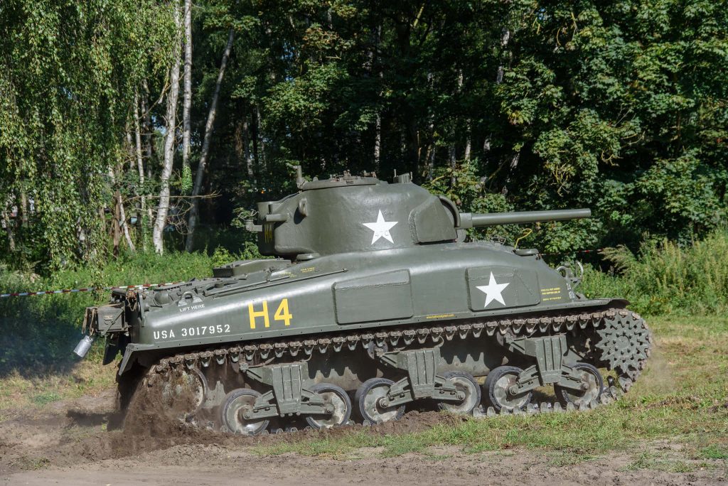 M4 Sherman tank in muddy forest terrain WWII American military historic wallpaper background