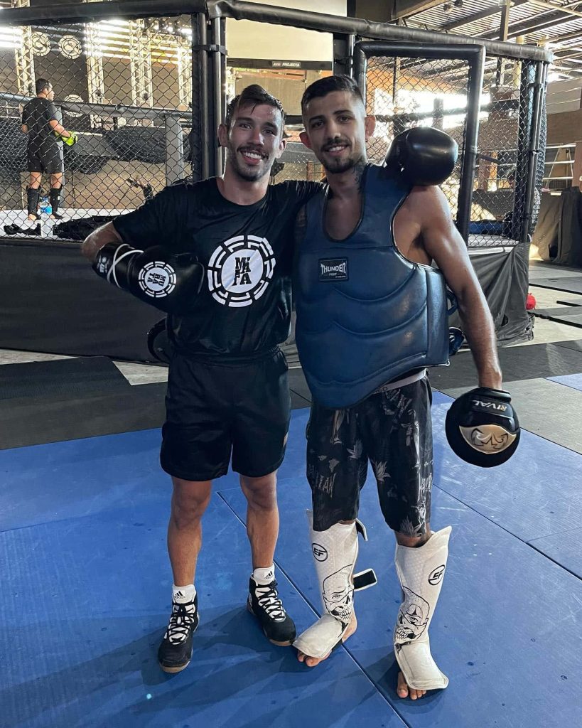 MMA fighter Matheus Nicolau training inside octagon with gloves and skull shin guards Wallpaper