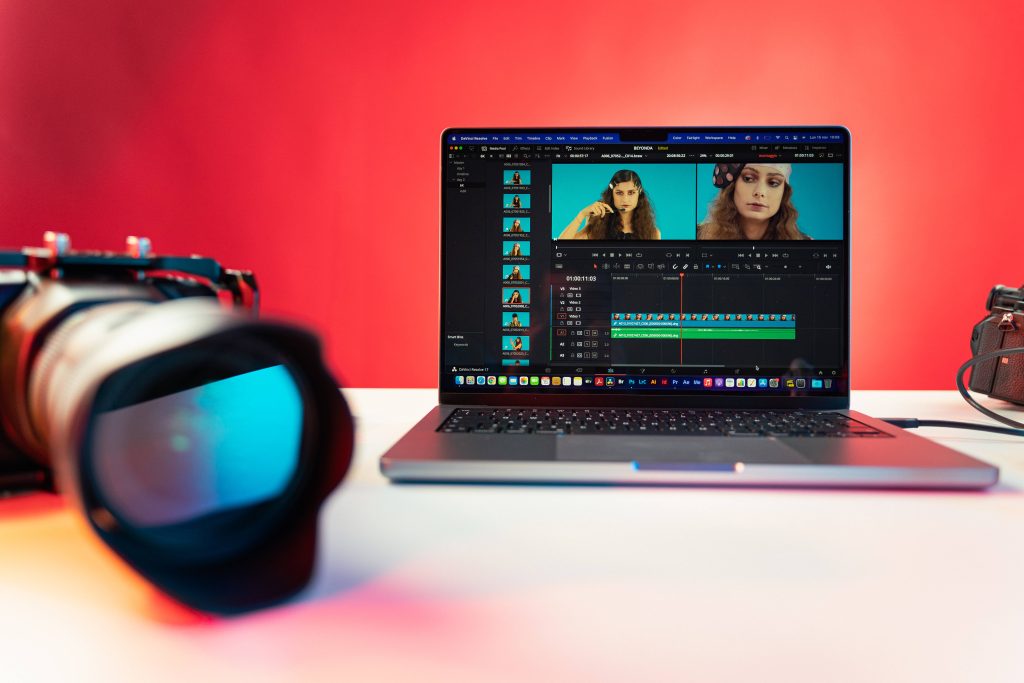 MacBook Pro with DaVinci Resolve 17 on white desk red background DSLR lens blur wallpaper