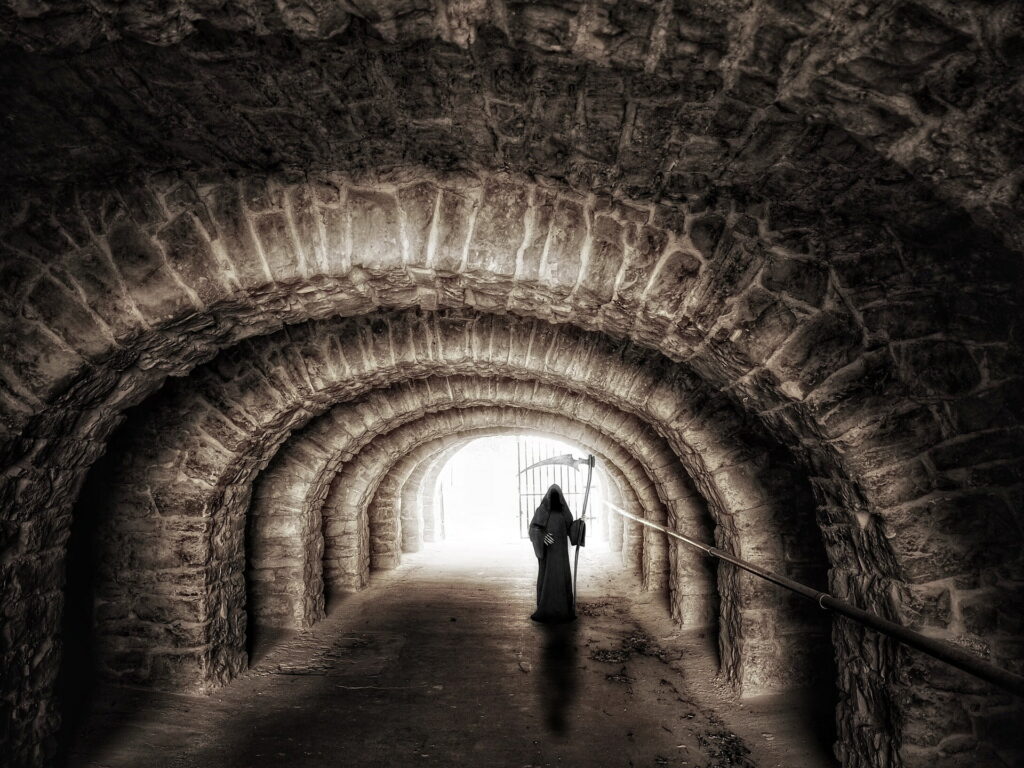 Dark cloaked figure in dimly lit stone tunnel - gothic and mysterious background image Wallpaper