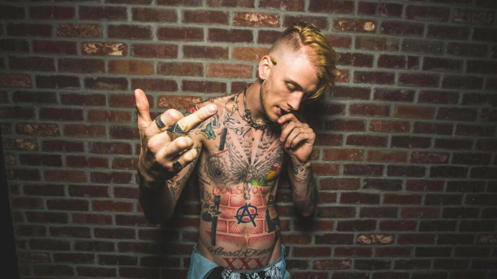 Machine Gun Kelly Shirtless Wallpaper Against Brick Wall Background