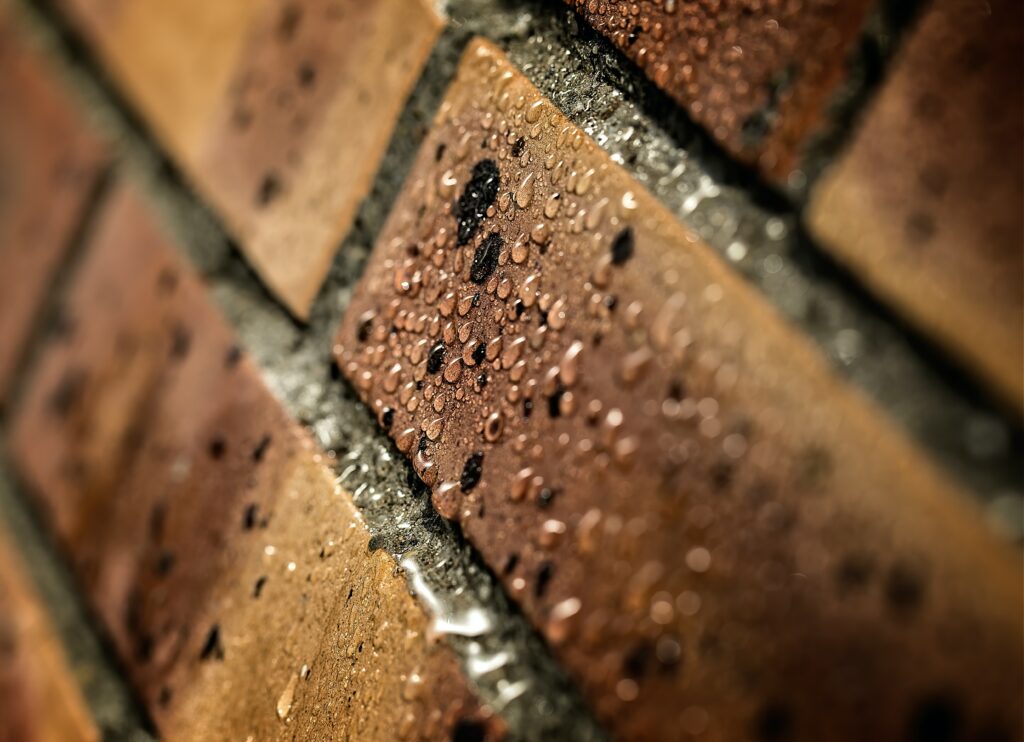 Close-Up Macro of Textured Brick Wall with Water Droplets Wallpaper