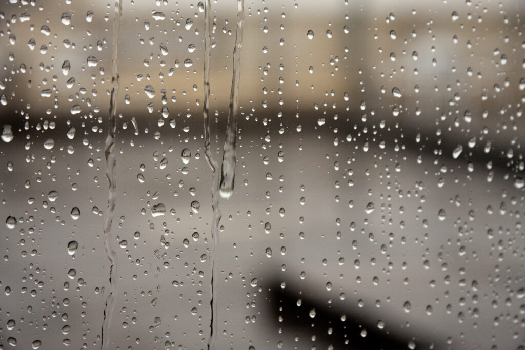 Macro Rain Droplets on Glass Surface - Serene Wallpaper Background