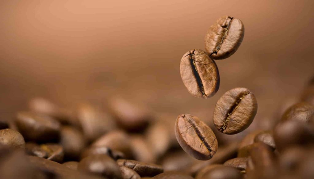Macro shot of roasted coffee beans falling with warm brown background and soft bokeh light Wallpaper