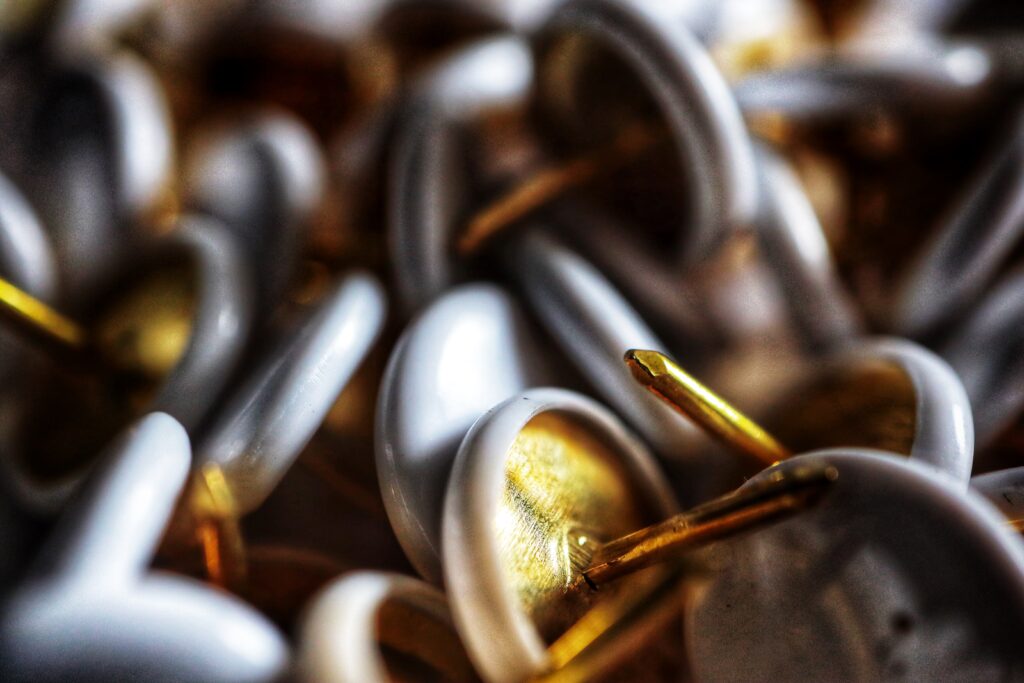 Macro Wallpaper of Shiny Metal Thumbtacks with Blurred Background