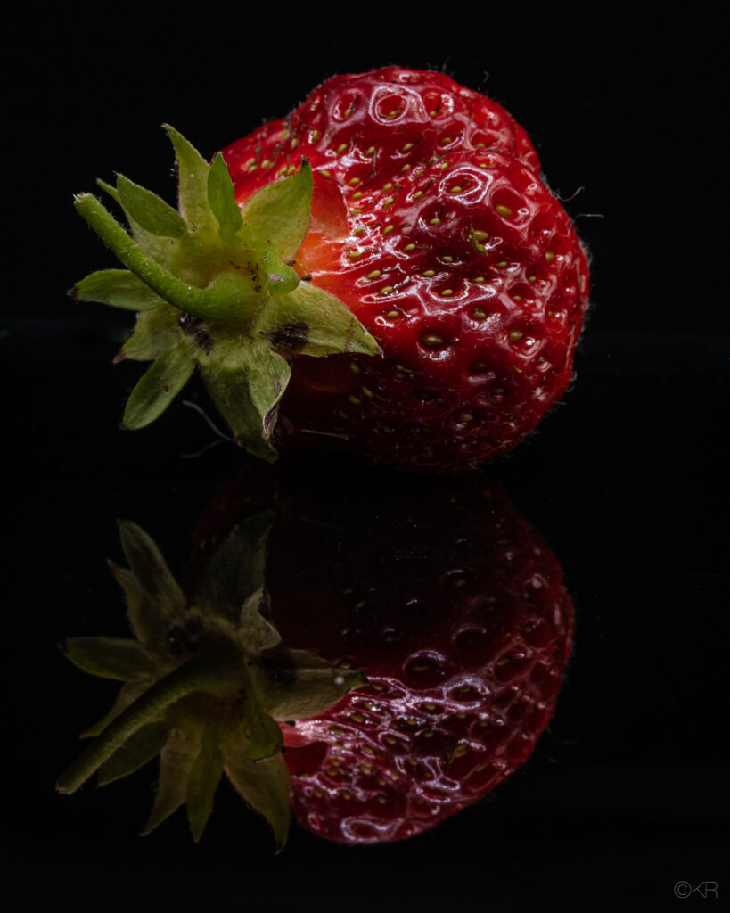 Close-Up Red Strawberry Wallpaper on Reflective Black Background