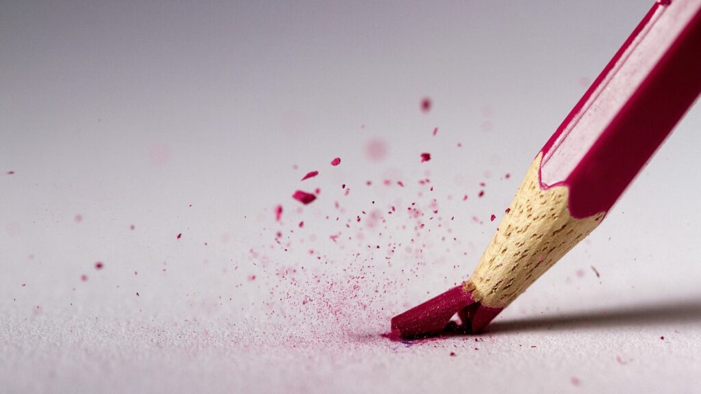 Vibrant Red Pencil Macro: Broken Tip & Fragments on White Background Wallpaper