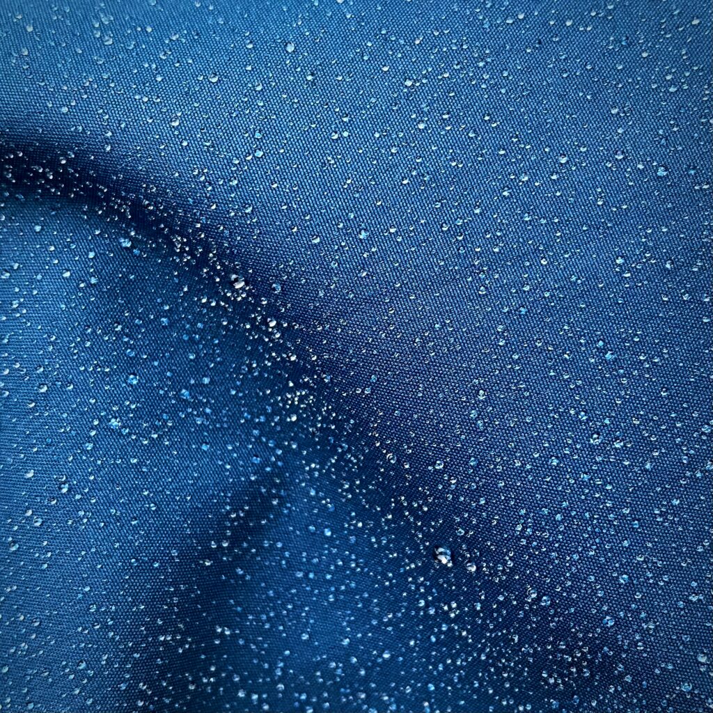 Macro Water Drops on Blue Cloth - Textured Wallpaper Background