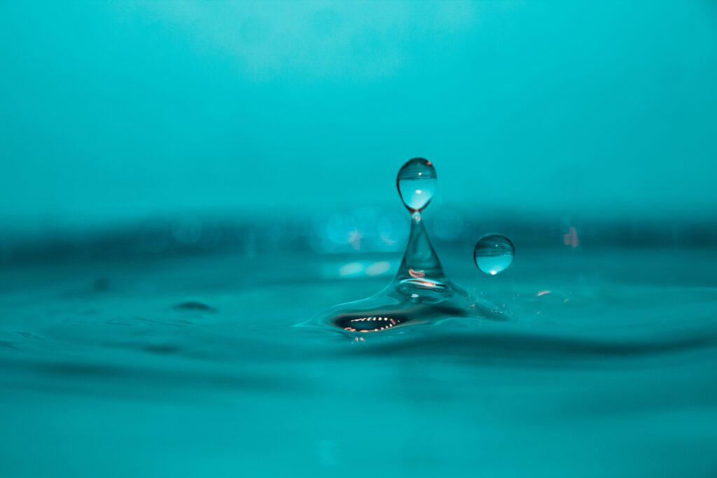 Macro Water Droplets in Motion: Serene Blue Wallpaper Background