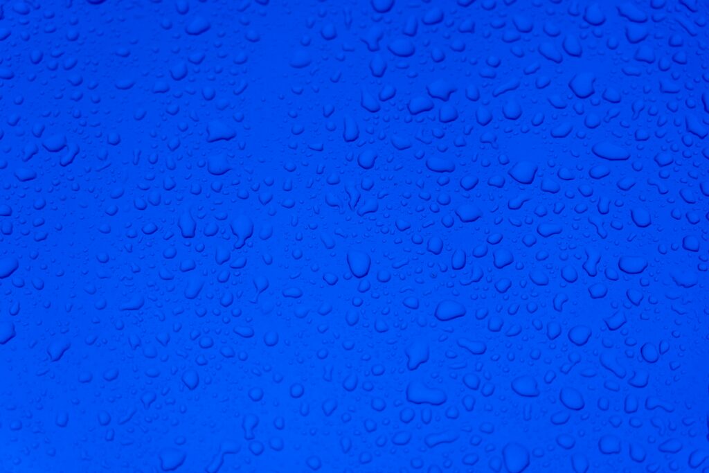 Serene Blue Surface Wallpaper: Macro Water Drops Background