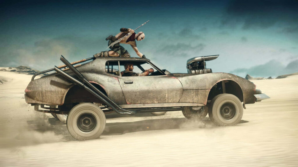 Mad Max armored car racing across dusty desert in intense high-speed chase under blue sky Wallpaper