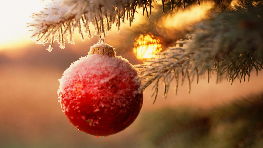 Enchanting Christmas Wallpaper: Snow-Dusted Ornament & Sunset Background