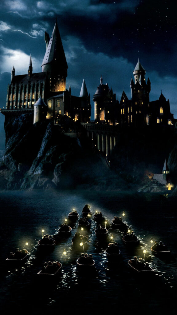 Disney castle glowing at dusk with twinkling lights reflecting on calm water wallpaper background