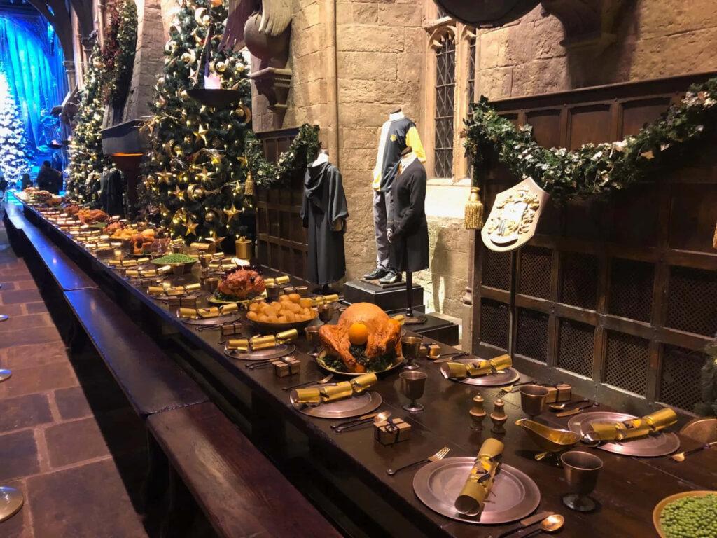 Enchanting Holiday Great Hall: Feast, Garlands & Glowing Lights Wallpaper