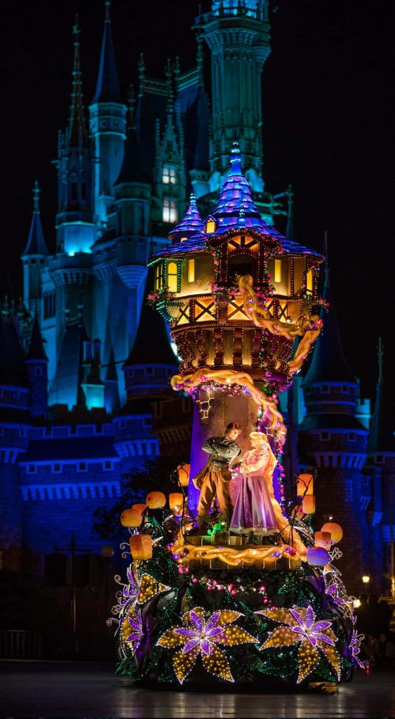 Tangled parade float with glowing Rapunzel Flynn Rider at blue-lit Cinderella Castle Disney wallpaper