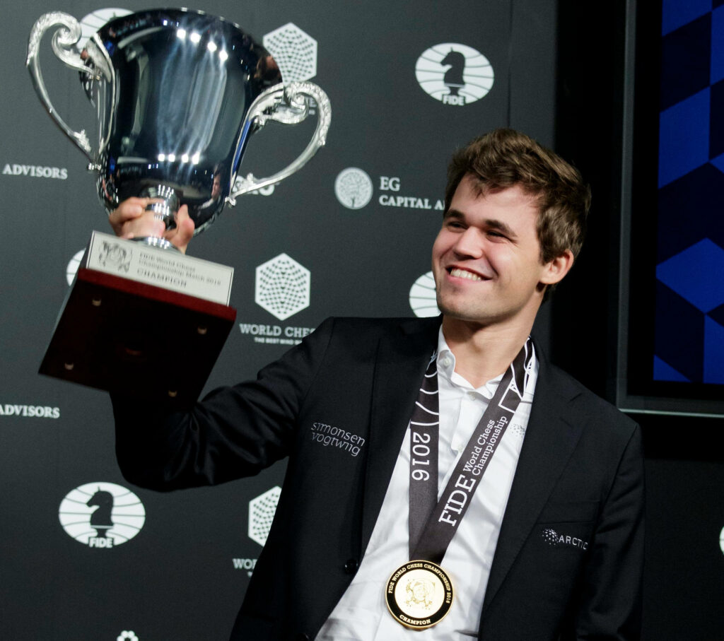 Magnus Carlsen Celebrates Chess Victory: Trophy & Medal Wallpaper