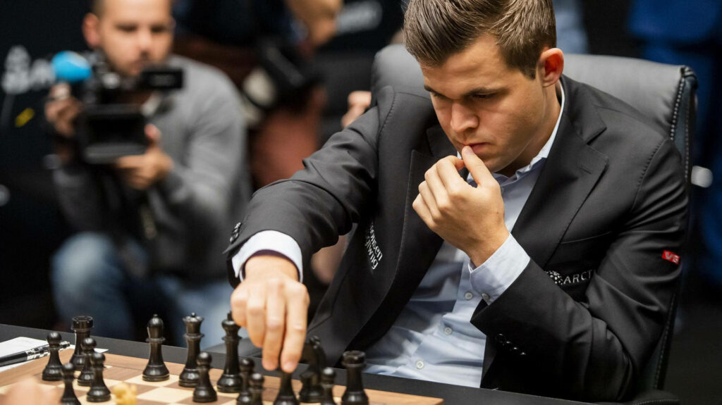 Magnus Carlsen Intense Chess Focus Wallpaper - Black Pieces Background