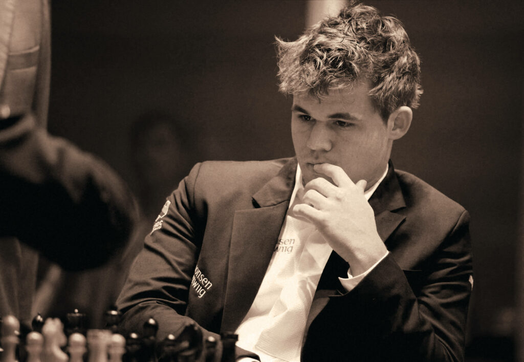 Thoughtful Magnus Carlsen Wallpaper: Focused Chess Master Background