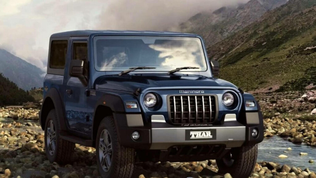 Mahindra Thar 2021 on rocky road with rugged mountains and dramatic clouds showcasing off-road power Wallpaper