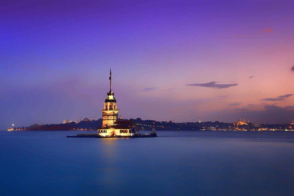 Sunset view of Istanbul Maiden’s Tower glowing over Bosphorus with city skyline silhouette wallpaper