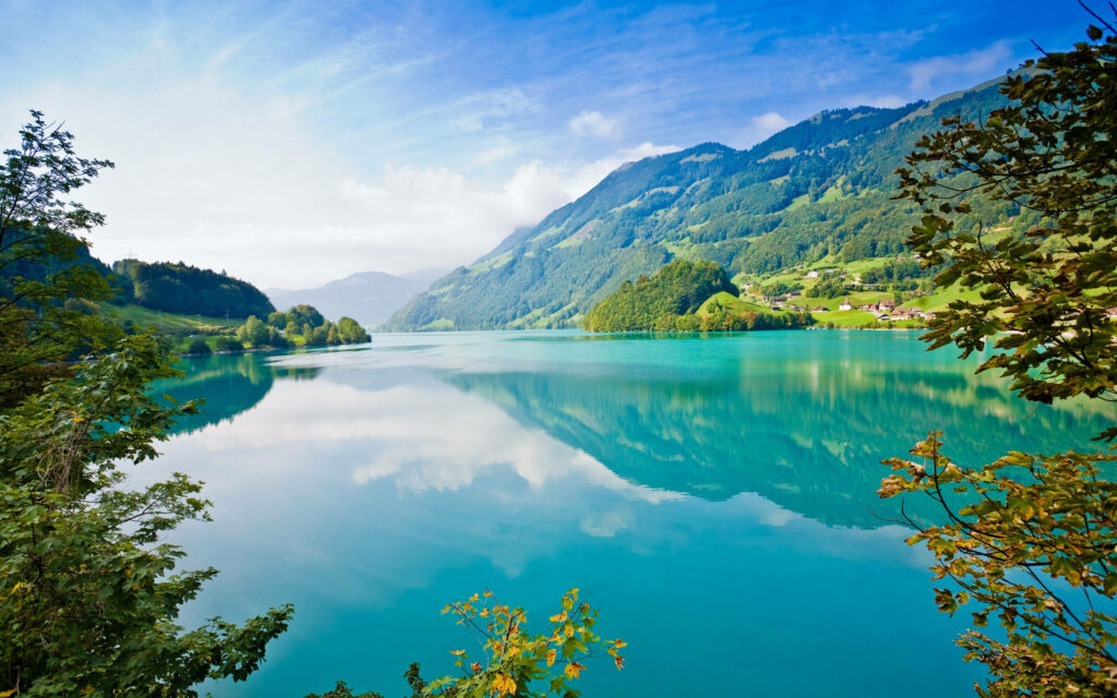 Enchanting Vista: High-Definition Desktop Wallpaper Showcasing a Majestic Mountain Range Embracing a Tranquil Sapphire Lake