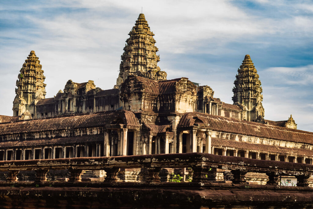 Majestic Angkor Thom ruins with intricate ancient stone architecture under vibrant sky wallpaper