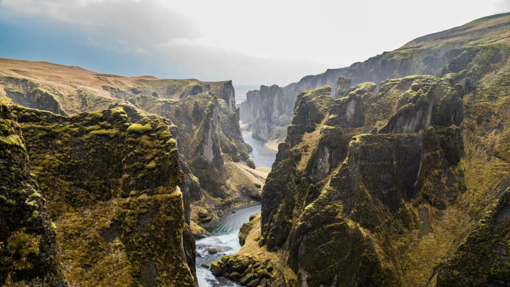 Majestic Landscape: The Enigmatic Fjaora River as it Winds Through Iceland's South-Eastern Canyon - A Stunning 2560x1440 Nature Background Wallpaper
