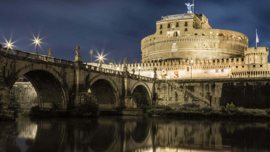 Castel Sant Angelo illuminated at night with ancient bridge and reflections in calm water Rome wallpaper