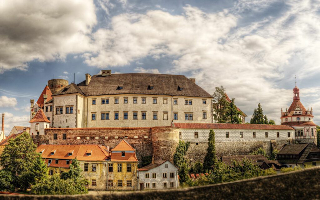 Majestic Castle Wallpaper: Charming Scene with Green Trees & Clouds