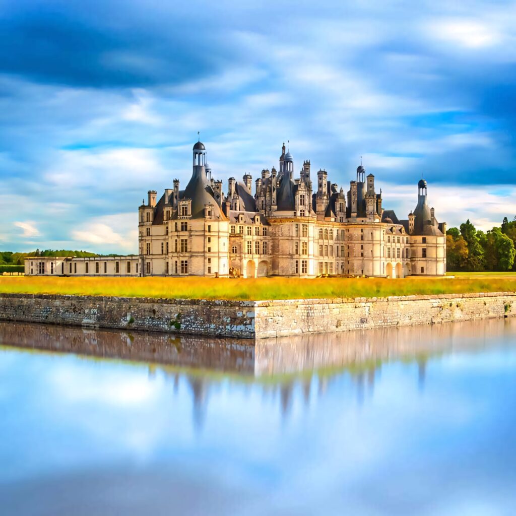 Château de Chambord Renaissance castle with turrets reflected in calm water under blue sky wallpaper