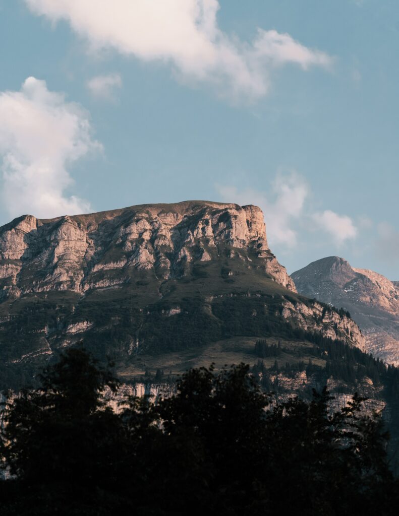 Majestic cliffs and rugged rocks under soft daylight with dramatic stone face and blue sky wallpaper